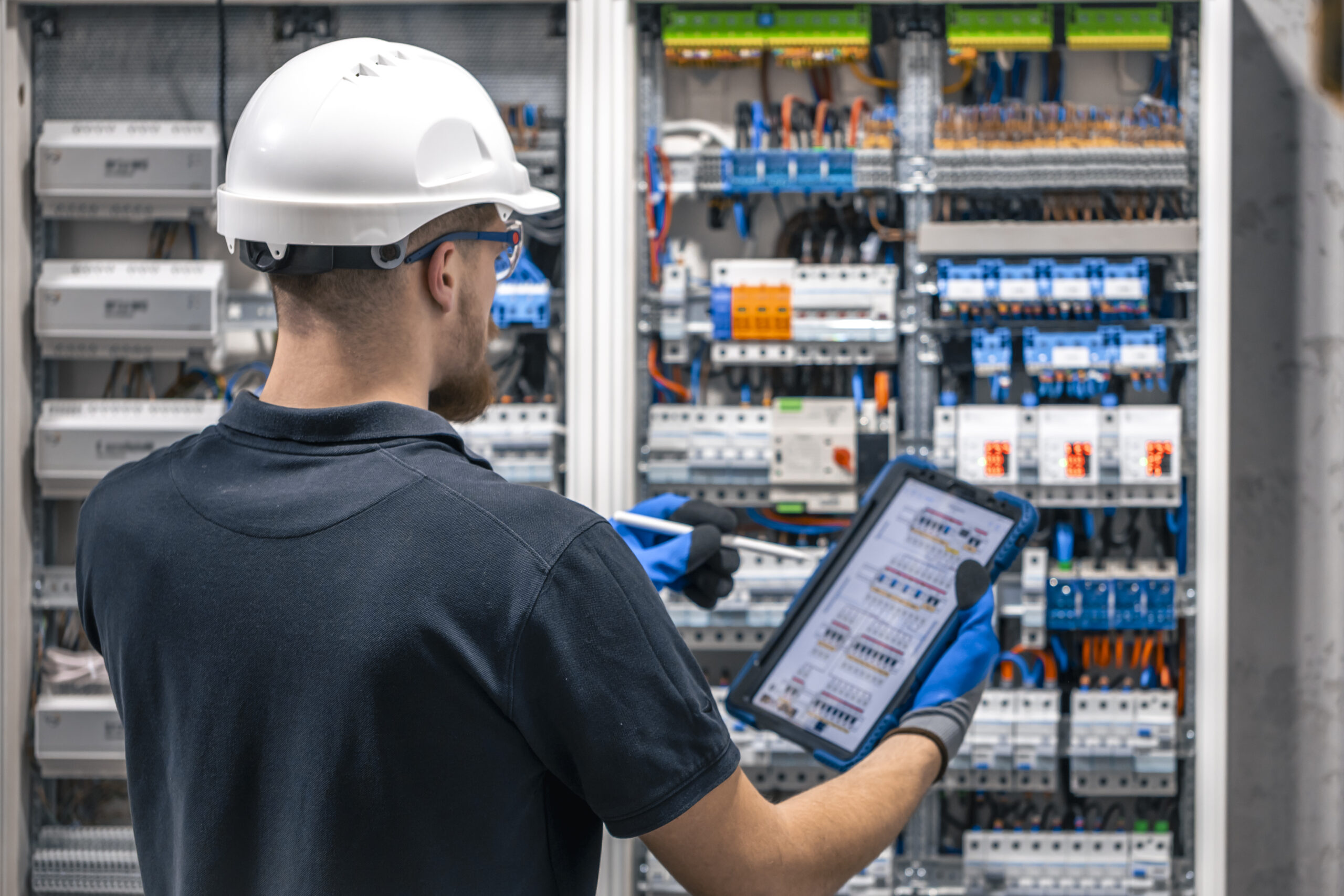 electrician-with-tablet-adjusting-circuitry-junction-box