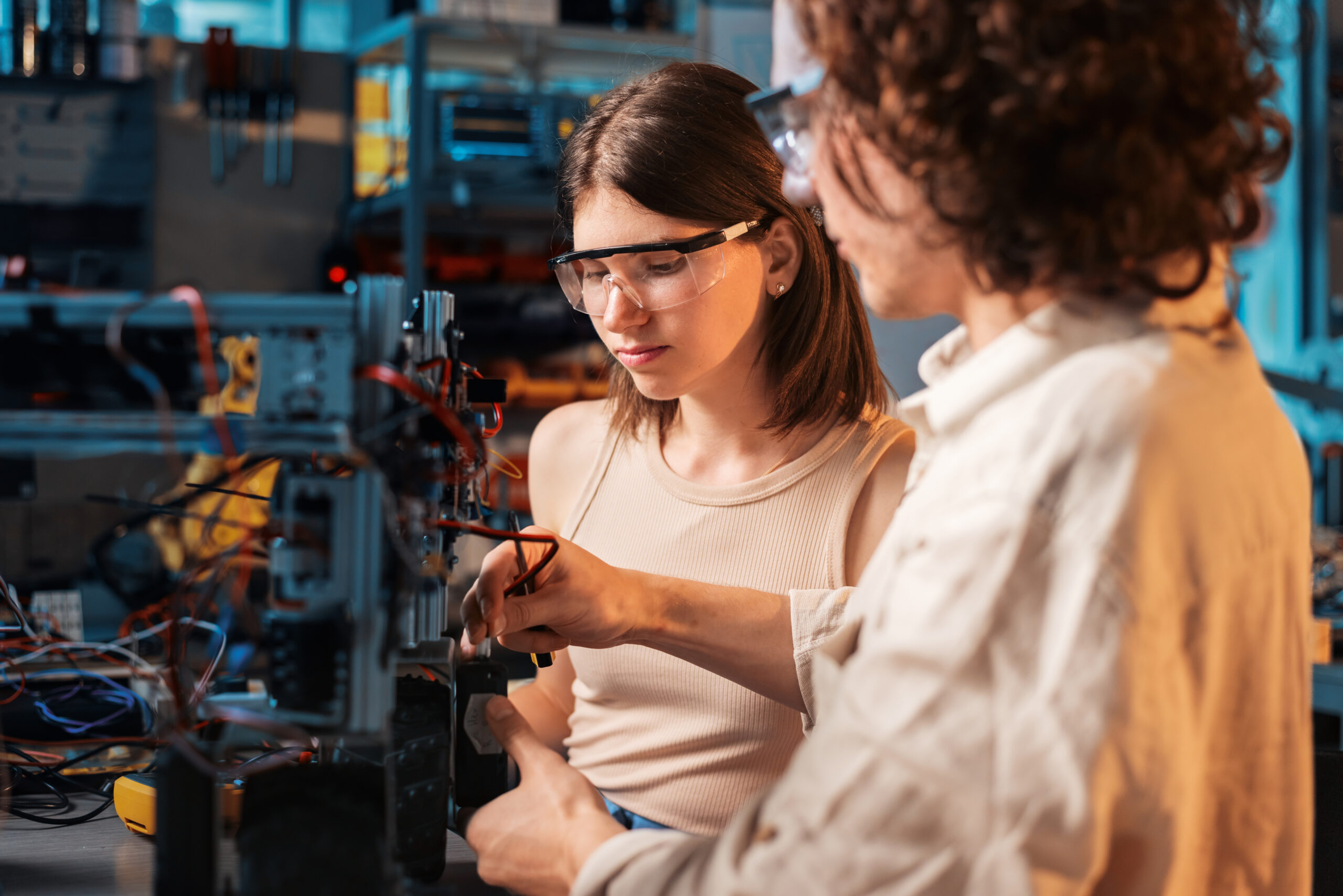 Young man and woman doing experiments in robotics in a laboratory